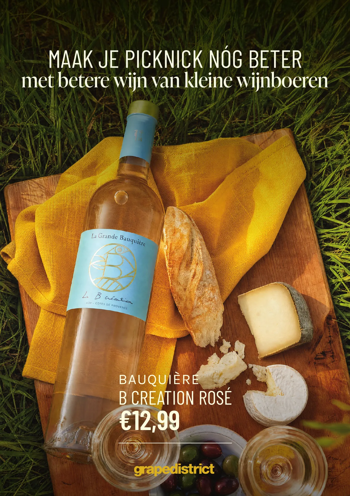 Zomercampagneposter: maak je picknick nóg beter, met een fles Bauquière rosé op een picknickkleed