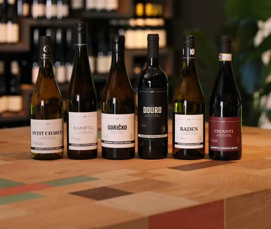 De flessen van de Grapedistrict anniversary collection op een kleurrijke houten tafel