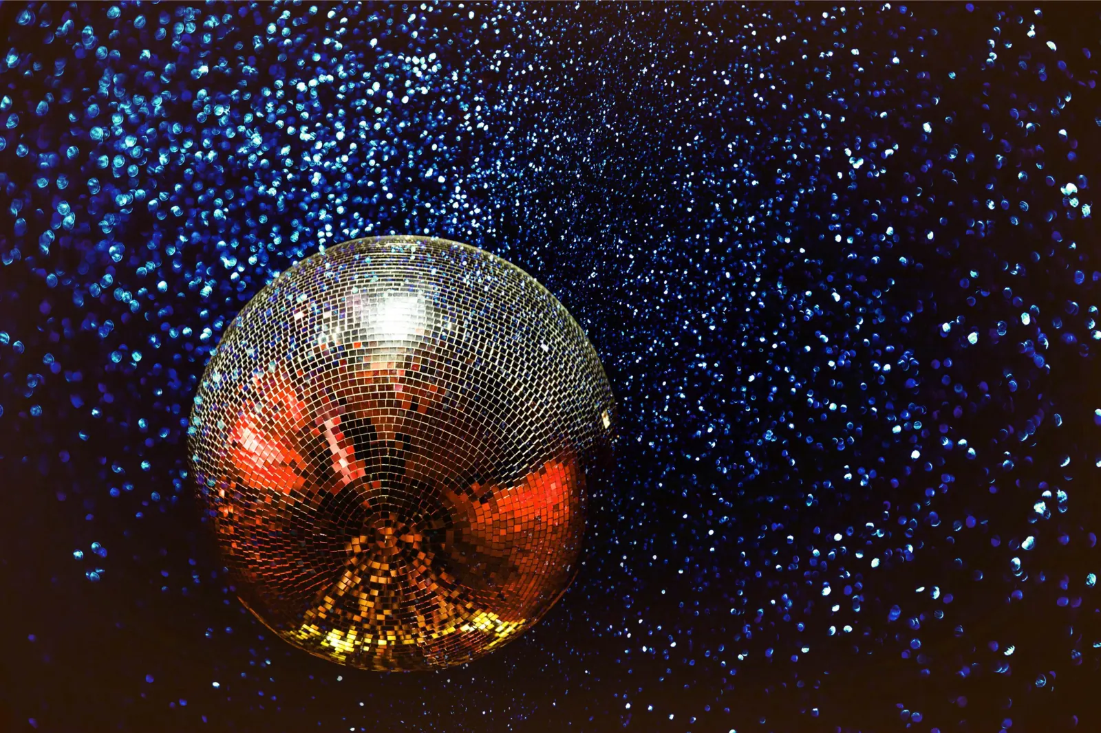 Discobal die oranje oplicht tegen een donkerblauwe achtergrond vol lichtstipjes